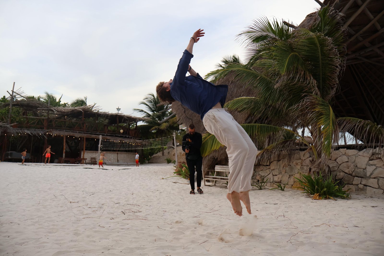 Kai mid-backflip on a beach
